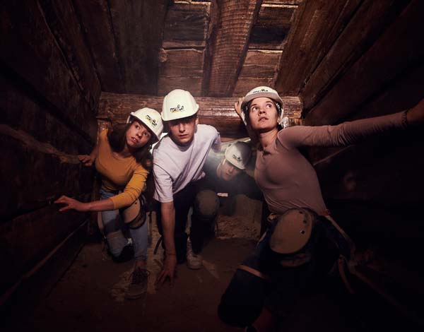 Eine Gruppe von Teilnehmern, die sich durch einen Schacht des Bergwerk Escape Room arbeiten.