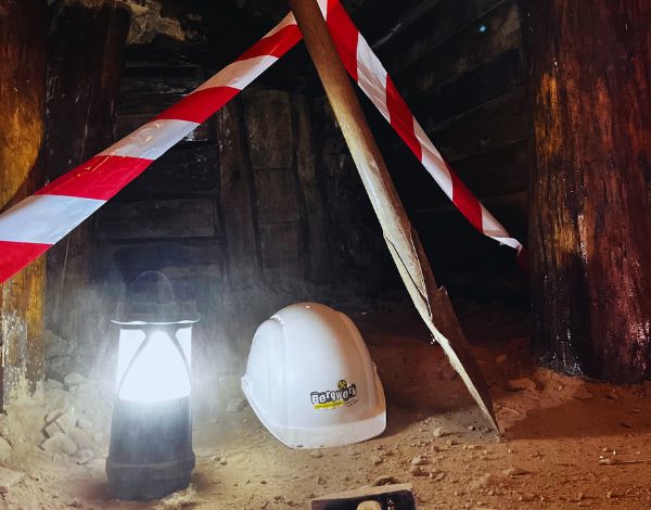 Zwei Frauen helfen sich durch eine �ffnung hochzuklettern